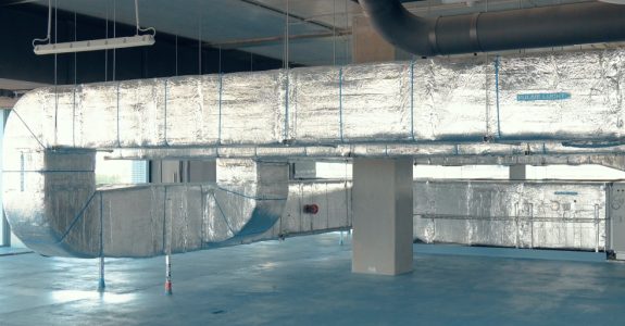 Grote luchtkanalen in een industriële ruimte.