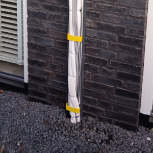 Geïsoleerde kabels bevestigd aan bakstenen muur buiten