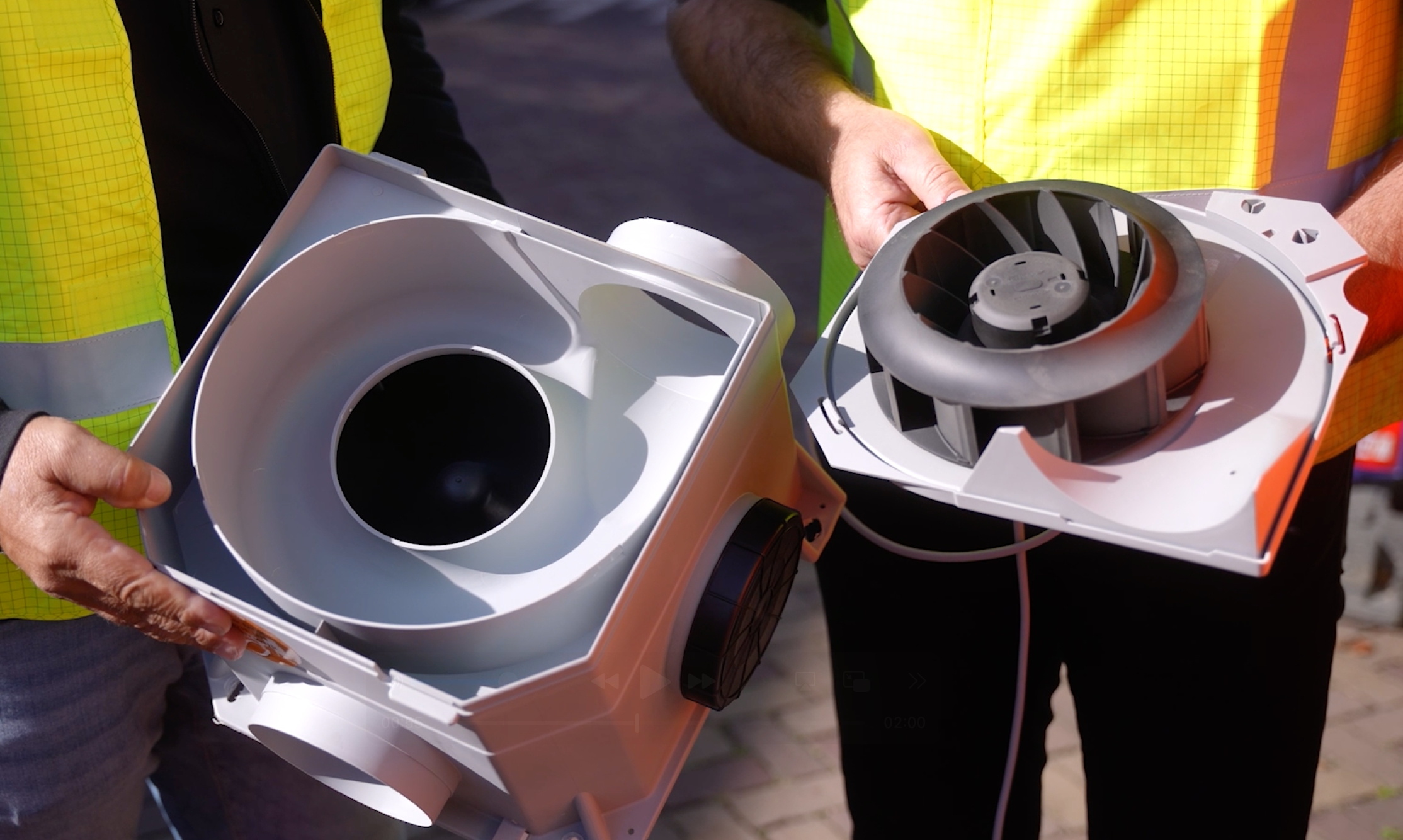 Twee personen met luchtventilatoren onderdelen.