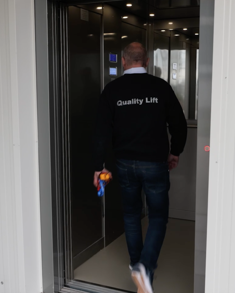 Man betreedt een lift met gereedschap in hand