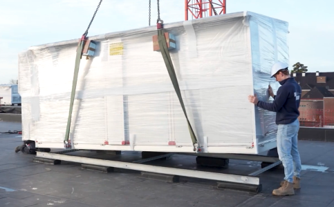 Grote pakketinstallatie op dak door bouwvakker