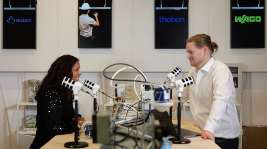 Podcastgesprek tussen man en vrouw met microfoons