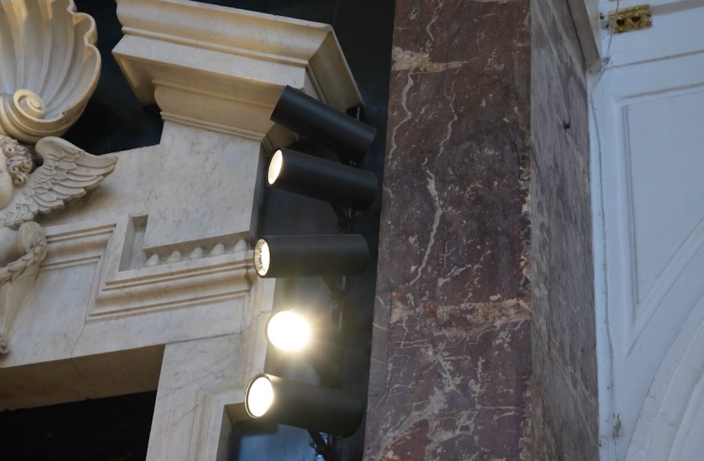 Architectonische details en schijnwerpers in historisch gebouw.