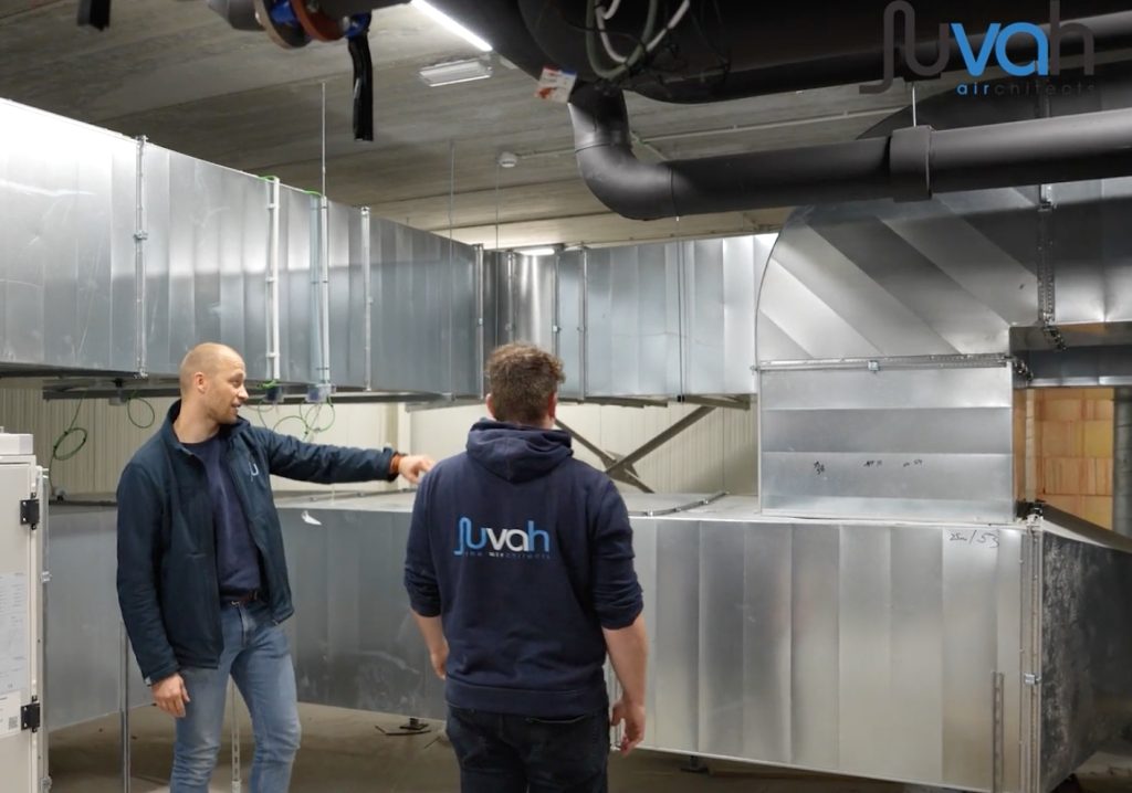 Twee mannen inspecteren ventilatiesysteem installatie